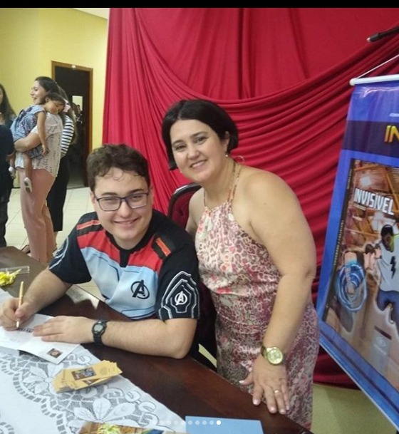 Aluno Ítalo Sanches e sua mãe Claudia Milhomem (figura 5),  em noite de autógrafos e lançamento de seu livro "Invisível - Segredos", produzido pelo aluno na Sala de Recursos Altas Habilidades, sob a orientação da Professora Rachel Rabelo.